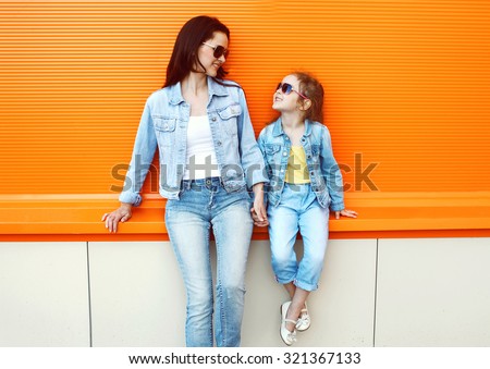 Happy mother and child wearing a jeans clothes in city