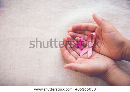 Hands holding Pink Ribbons toning background, Breast cancer awareness and Abdominal cancer awareness