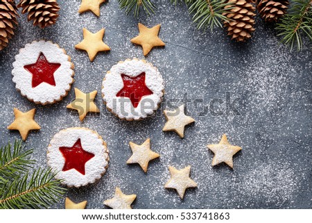 Christmas or New Year homemade ginger cookies star with strawberry jam. Traditional Austrian dessert - Linzer biscuits. Flat lay. Festive decoration. Top view. Copy space.