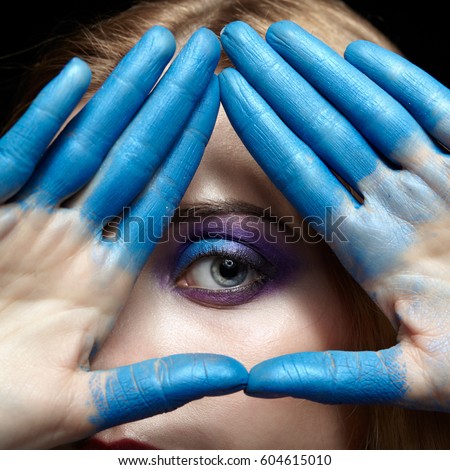 Eye of Providence eye pyramid Illuminati and mason symbol made of hands and female face with blue paint on fingers