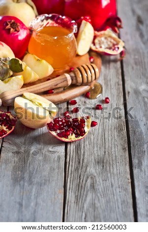 Pomegranate, apple and honey, traditional food of jewish New Year celebration, Rosh Hashana. Selective focus. Copyspace background