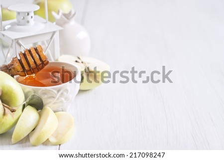 Apple and honey, traditional food of jewish New Year celebration, Rosh Hashana. Selective focus. Copyspace background. High key.