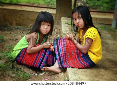 Dien Bien Phu, Dien Bien, Vietnam August 1, 2014: Two unidentified Hmong child is sitting under a tree.