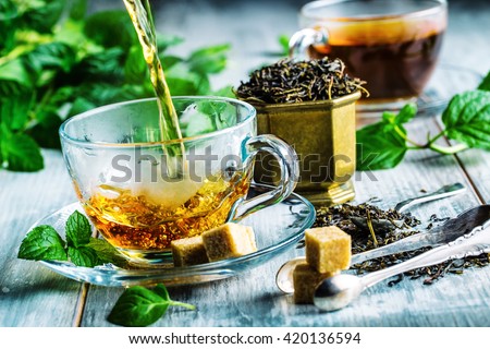 Tea. Mint Tea. Herbal tea. Mint leaf. Mint leaves. Tea in a glass cup, mint leaves, dried tea, sliced lime. herbs tea and mint leaves on a slate plate in a restaurant or teahouse tea room.