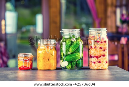 Preserving. Pickles jars. Jars with pickles, pumpkin dip, white cabbage, roasted red yellow pepper. Pickled Vegetables. Vegetable being prepared for preserving. Toned image.