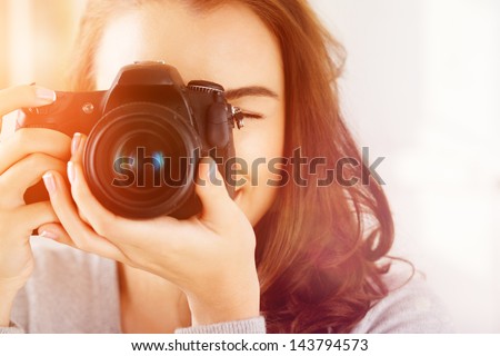 Pretty woman is a professional photographer with dslr camera