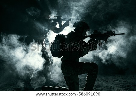 Pair of army soldiers attacking in the smoke. Backlit silhouette, toned image. Army storm concept