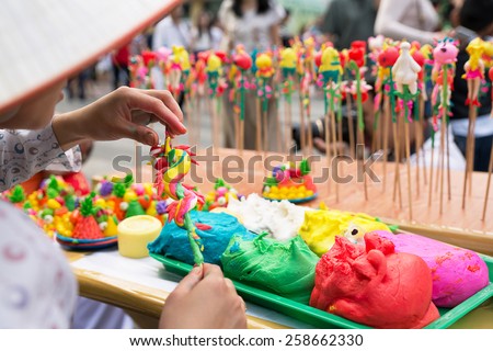 A Vietnamese crafstwoman is shaping "to he" toy, which is made of powder and colorful dyes.