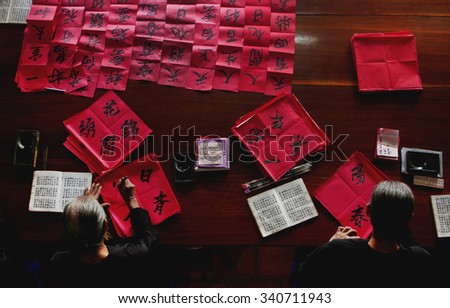 LONG HAI, VIETNAM - JAN 21, 2014: Two unknown old men are writing Han Nom words - a kind of letters that used to be famous during feudalism. They are given to visitors to wish they luck in new year.
