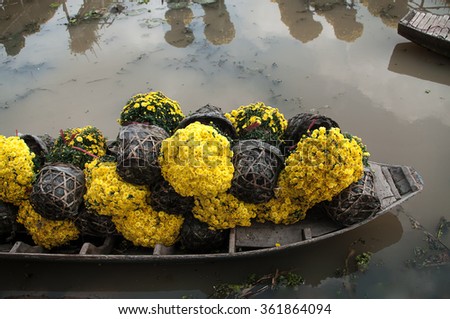 SA DEC, DONG THAP PROVINCE, VIETNAM - Feb 07, 2015: Unknown man in Vietnamese conical hat and traditional dress is using sampan to harvest flowers in Sa Dec Flower village. This is to prepare for Tet