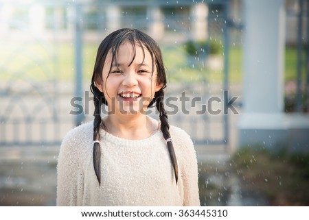 Beautiful asian girl is happy with the rain
