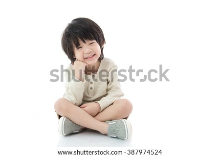 Happy asian boy sitting on white background isolated