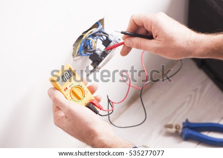 Close up of electrician hands fixing a socket