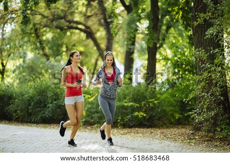 Athletic women exercising by jogging in nature