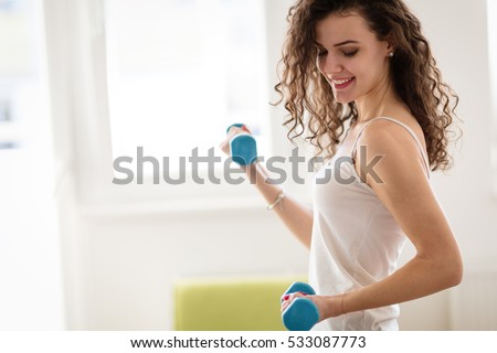Sporty beautiful woman exercising at home to stay fit