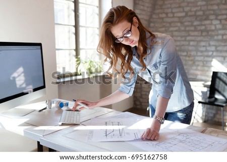 Female designer in office working on architects project
