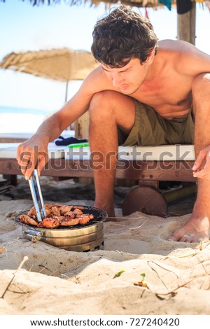 Image result for guy cooking on a beach