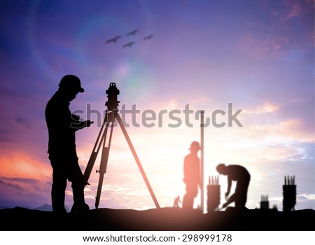 silhouette black man survey civil engineer stand on ground working in a land building site over Blurred construction worker on industrial site.
