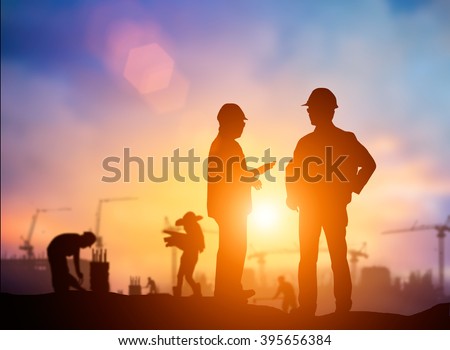 Silhouette Successful male engineer standing survey work on construction over blurred Worker in construction site and nature