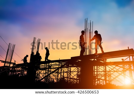 Silhouette engineer standing orders for construction crews to work on high ground heavy industry and safety concept over blurred natural background sunset pastel