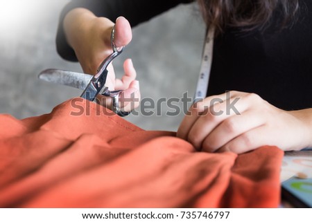 Hands notch tailor tailor's scissors cloth cutting a piece of fabric (fashion designer concept)
