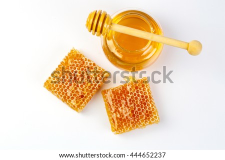 Honeycomb with jar and honey dipper isolated on white background