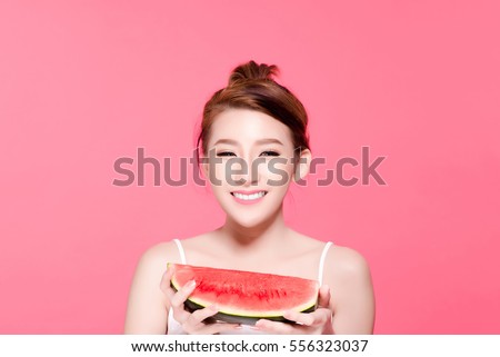 Healthy asian young woman eat watermelon, This girl really love fruits, She have beauty face and natural makeup, Isolated over pink background.
