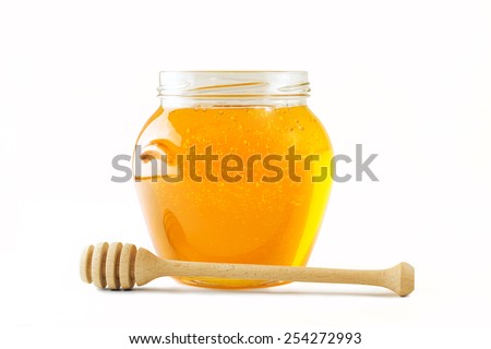 Glass jar full of honey wooden honey dipper