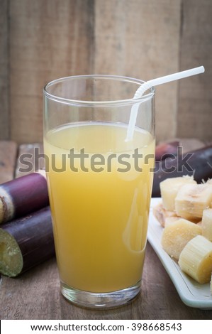 Glass of sugarcane juice on wood floor.