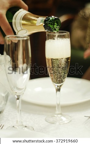 the process of pouring champagne into a glass