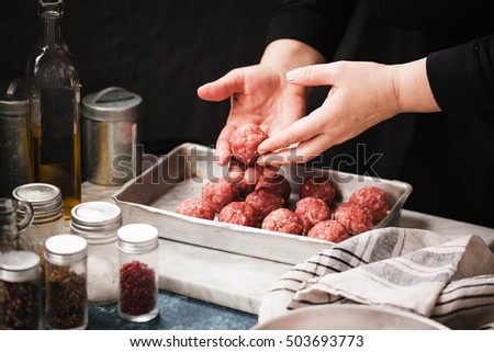 Female Hand Preparing Beef Meatballs In Cooking Sheet On Marble Board Female Hand Preparing Beef Meatballs In Cooking Sheet On Marble Board