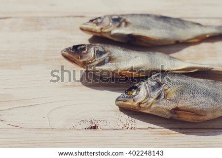 Dried fish on the table. Salty dry river fish on a wooden impressive background.