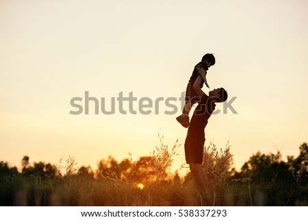 photo happy joyful father having fun throws up in the air child, family, travel, vacation, father's day - concept. Sunlight on the sunset