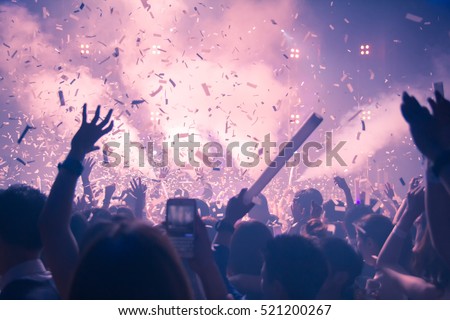 Silhouette hands of audience crowd people use smart phones enjoying the club party with concert. Celebrate new year party , Blurry night club DJ party music dancing sound of RCA Bangkok Thailand.