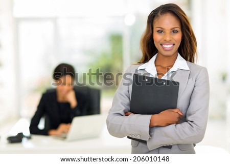 black business woman holding clipboard with colleague on background