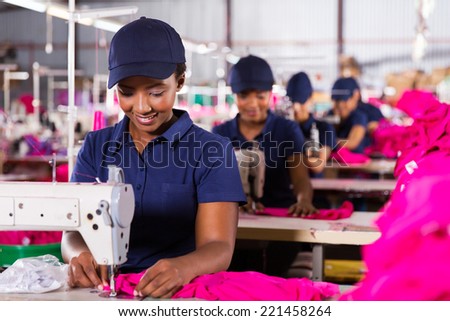 young african textile worker sewing on production line