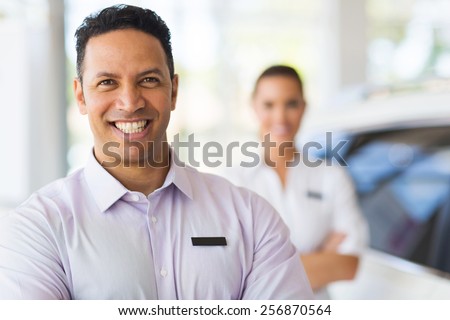 car salesman standing in front of colleague in showroom