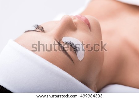 Beautiful young woman during eyelash extension