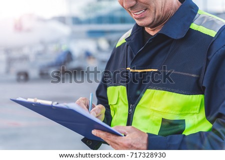 Airport technical staff hand making notes