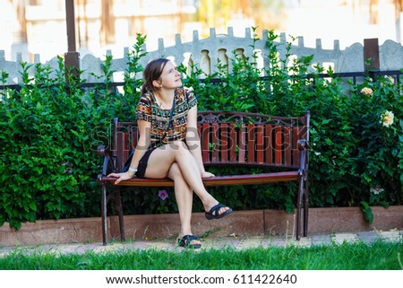 https://thumb1.shutterstock.com/display_pic_with_logo/2712496/611422640/stock-photo-pretty-young-woman-sitting-on-a-bench-in-the-park-on-background-of-bright-green-foliage-selective-611422640.jpg