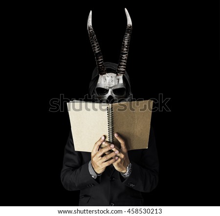 A skull guy with horns in black suit reading notebook, on black dark background A skull guy with horns in black suit reading notebook, on black dark background