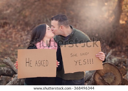https://thumb1.shutterstock.com/display_pic_with_logo/2752207/368496344/stock-photo-engaged-couple-kissing-and-holding-cardboard-signs-on-a-chilly-autumn-day-368496344.jpg