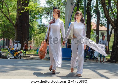 HOCHIMINH CITY, VIETNAM, FEBRUARY 16 : unidentified Vietnamese girls wearing white Ao dai on the street on February 16, 2014. Ao dai is famous traditional Custume for women in Vietnam.