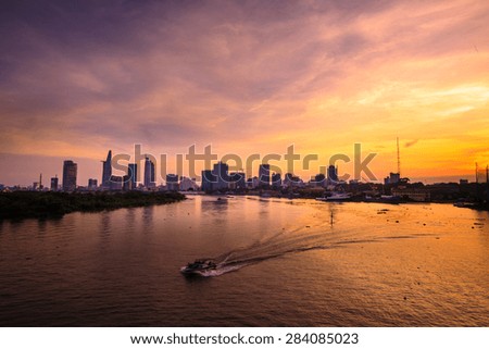 Ho Chi Minh's Panorama view over the Saigon River. Dramatic lighting spectacular sunset is highlighted by a canoe surfing on the water at a faster rate