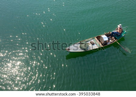 Tri An Lake, Dong Nai Province, Vietnam - March 6, 2016: A fisherman's boat on the lake in the early morning. This is a fisherman who lives in the fishing village of Tri An Lake