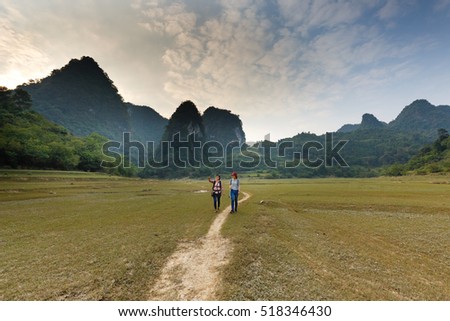 Nam Cha, Cao Bang province, Vietnam - September 22, 2016 : Two young girls traveling to explore wilderness lake Nam Cha. Scene here is spectacular with huge limestone mountains of Cao Bang, Vietnam