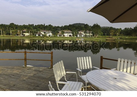 Flamingo Dai Lai, Vinh Phuc province, Vietnam - October 13, 2016 : table and chairs on wooden pier on shore of lake in summer landscape at Flamingo resort Dai Lai, Vietnam