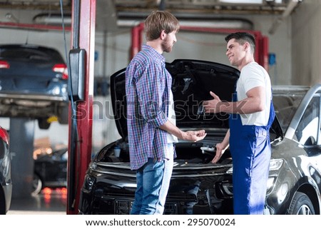 Mechanic giving client keys to his repaired car