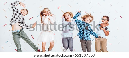 Cheerful young kids jumping in the air with a smile on their faces