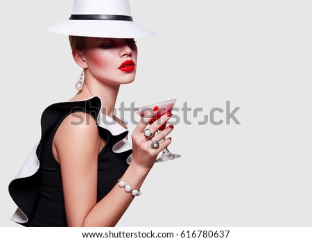 Girl in white hat covers her face. Girl with a glass of cocktail in hand.
Girl drinks cocktail. Strawberry milkshake. The charming stranger.